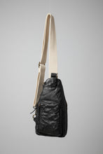 Black leather sling bag with a off white strap