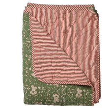 Folded fabric with pink and green patterns on a white background