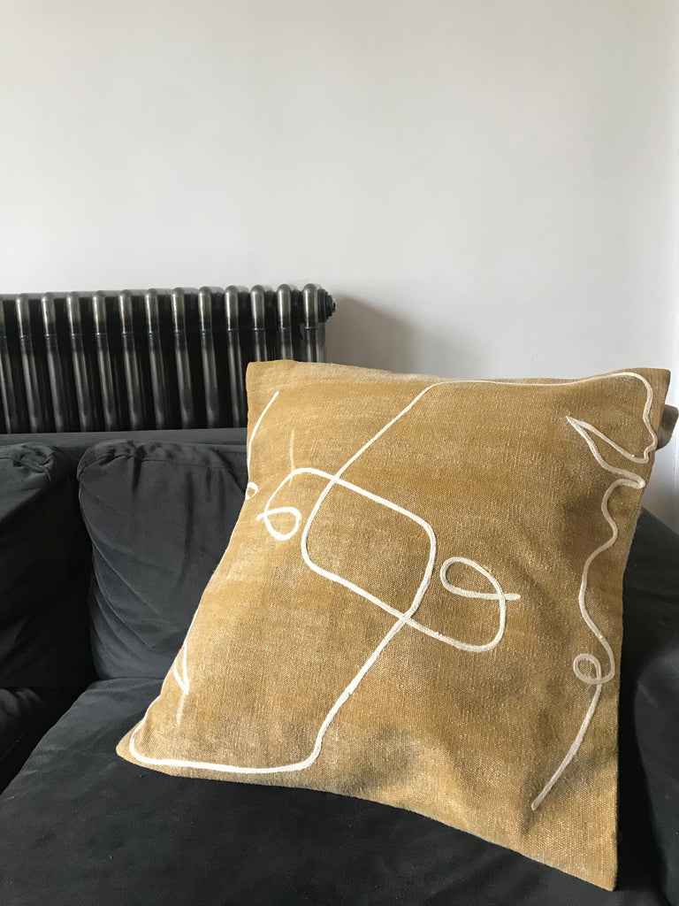 Embroidered ochre cushion